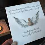 Perspex Quotable board 15cm & pebble image standing on a T-Light wooden block 
Pebble person with open beautiful angel wings in grey & white shades
Quote;
Light this candle, see it glow, watch it dance when you feel low.
Think of me, see the light.  I'll always be here, day or night.
A candle flickers out of sight. 
but in your heart I still burn bright.