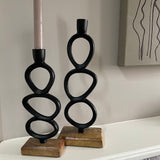 Minimal Sculptural Black Iron Dinner Candle holder - 35cm & 25cm Celebrate minimalism with this top trending iron candle stick with a rustic hammered metal black finish. The sculptural design set on a chunky wooden base is like a piece of artwork. Beautiful for displaying around the home.