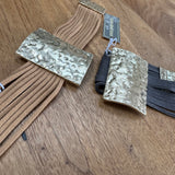 Eliza Gracious quality - affordable design led branded costume jewellery.
Multi stranded suede Bracelet with a beaten pale gold effect magnetic fastener and bar 3.5x5cm detail 
Available in Beige/tan or Dark Grey
