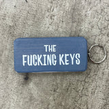Made in the UK by Giggle Gift Co. Wooden block keyring with white text quote on both sides; 'The Fucking Keys' grey