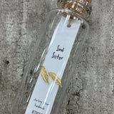 Sweet feather shaped stud earrings presented in a message bottle on a card that reads "soul sister"  Sterling Silver - available in gold or silver - pictured here is gold