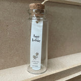 Sweet flower shaped stud earrings presented in a message bottle on a card that reads "happy birthday"  Sterling Silver