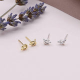 Sweet knot shaped stud earrings presented in a message bottle on a card that reads "our friendship is a knot”  Sterling Silver