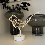 A gorgeous caged white Robin wrapped in 20 warm white LEDs, stood on a round block. Stunning accessory for the home that transforms from day to night, looks great displayed on a shelf or windowsill.