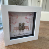 Mini Framed Pebble Art -White block square frame 12.5cm With a soft background image of trees and a bench with two pebble friends sitting together with the quote 'Life is better with friends'