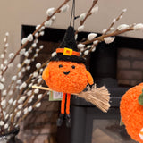 Fabric pumpkin witch decoration riding a tiny broomstick