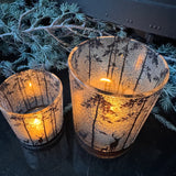 Frosted Glass Candle Holders featuring trees &amp; deer detail around the exterior
Available in 2 sizes - Small 8cm &amp; Large 12.5cm