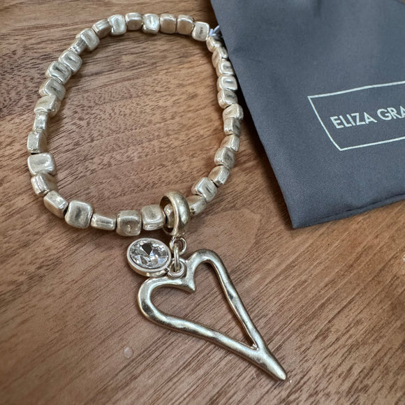 Eliza Gracious quality affordable design led branded costume jewellery 

Stretch square bead bracelet with heart & crystal charm 
Available in Burnished Pale Gold EB0374