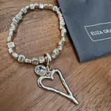 Eliza Gracious quality affordable design led branded costume jewellery&nbsp;

Stretch square bead bracelet with heart &amp; crystal charm&nbsp;
Available in Burnished Pale Gold EB0374