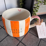 Belly Button Designs - Mabel Range
Stoneware Mug 340ml hand-painted wide, orange &amp; white vertical stripes
Text stamped on the front - Lovely Friend&nbsp;