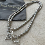 Eliza Gracious quality - affordable design led branded costume jewellery.  Long or short Light Grey seed shape Freshwater Pearl Necklace with twin hearts charm