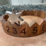Decorative round wooden advent countdown tray 29cm; features carved numbered sections and a metal star marker to move on daily..&nbsp;
