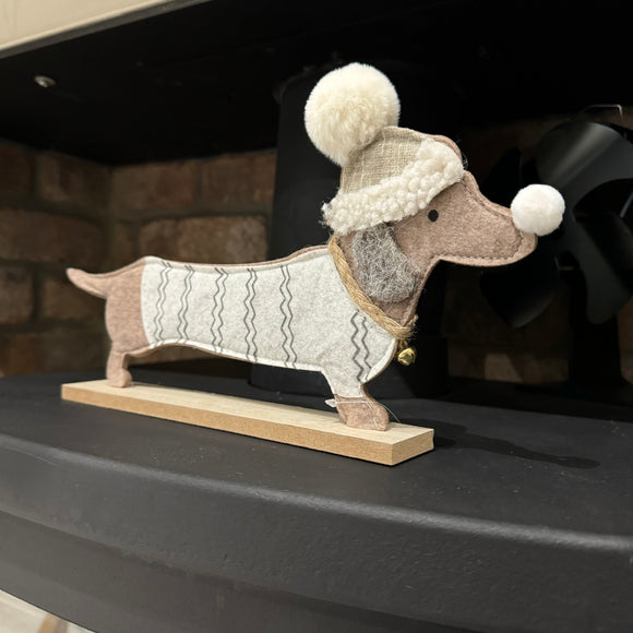 Sausage dog / Dachshund long felt dog ornament on a wooden base
Dog is wearing a jumper and hat in brown & beige colours L30cm 
