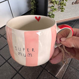 Belly Button Designs - Mabel Range
Stoneware Mug 340ml hand-painted wide, pastel pink &amp; white vertical stripes
Text stamped on the front - Super Mum