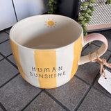 Belly Button Designs - Mabel Range
Stoneware Mug 340ml hand-painted wide, yellow &amp; white vertical stripes
Text stamped on the front - Human Sunshine