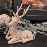 Elegant resting Reindeer figurine with detailed antlers features a textured, frosty finish with intricate, swirl-embossed scrollwork along its body H22cm&nbsp;