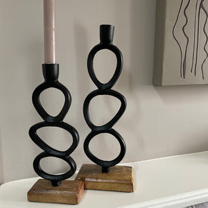 Minimal Sculptural Black Iron Dinner Candle holder - 35cm & 25cm Celebrate minimalism with this top trending iron candle stick with a rustic hammered metal black finish. The sculptural design set on a chunky wooden base is like a piece of artwork. Beautiful for displaying around the home. 