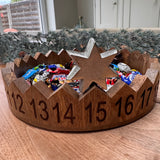 Decorative round wooden advent countdown tray 29cm; features carved numbered sections and a metal star marker to move on daily..&nbsp;

