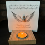 Perspex Quotable board 15cm &amp; pebble image standing on a T-Light wooden block&nbsp;

Pebble person with open beautiful angel wings in grey &amp; white shades

Quote;

Light this candle, see it glow, watch it dance when you feel low.

Think of me, see the light.&nbsp; I'll always be here, day or night.

A candle flickers out of sight.&nbsp;

but in your heart I still burn bright.