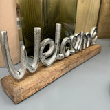 Metal 'Welcome' sign on Wooden plinth