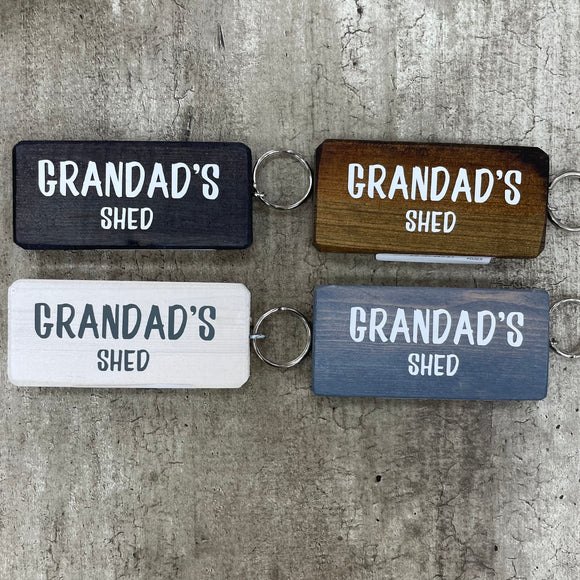 Made in the UK by Giggle Gift Co. Wooden block keyring 10cm with white text quote on both sides; 'Grandad's Shed' 