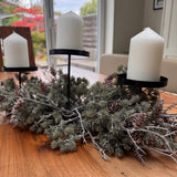 Triple candle holder Needle Pinecone Table Centre L60cm&nbsp;

Tiered black metal frame with three flat pillar candle plates, nestled inside a bed of realistic artificial frosted long-needle pine branches and real pinecones.