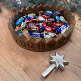 Decorative round wooden advent countdown tray 29cm; features carved numbered sections and a metal star marker to move on daily..&nbsp;

