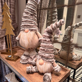 Standing Gonk with extendable legs & Sitting Gonk wearing a tall ribbed faux fur grey hat, button nose and a fluffy white beard with gold threads giving it a little sparkle 