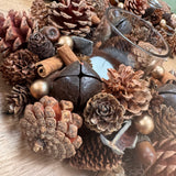 Round T-light Centrepiece layers of Pinecones, cinnamon sticks..