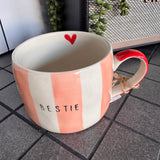 Belly Button Designs - Mabel Range
Stoneware Mug 340ml hand-painted wide, pastel pink &amp; white vertical stripes
Text stamped on the front - Bestie