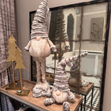 Standing Gonk with extendable legs & Sitting Gonk wearing a tall ribbed faux fur grey hat, button nose and a fluffy white beard with gold threads giving it a little sparkle 