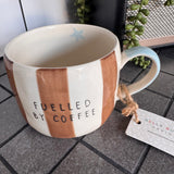 Belly Button Designs - Mabel Range
Stoneware Mug 340ml hand-painted wide, earthy brown &amp; white vertical stripes
Text stamped on the front - Fuelled by Coffee