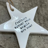 White ceramic hanging star 8.5cm with sentimental quote; 'Feathers appear when angels are near'