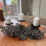 Triple candle holder Needle Pinecone Table Centre L60cm&nbsp;

Tiered black metal frame with three flat pillar candle plates, nestled inside a bed of realistic artificial frosted long-needle pine branches and real pinecones.