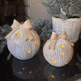 Neutral glazed Ceramic LED detailed Bauble with a ribbed design &amp; rough textured bow topper and lots of open stars &amp; dots to let the light through when switched on..
Available in 2 sizes - Small H10cm &amp; Large H12cm