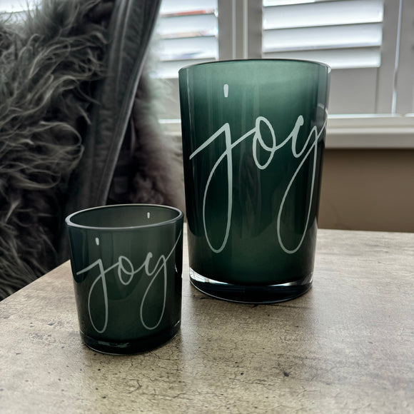 Round Glass Hurricane Vase in a Deep Green/Grey colour
Has the word 'Joy' in a scrolling text on both sides
Available in 2 sizes; Small H8cm & Large H18cm 