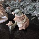 Festive charming Hedgehog wearing a sage scarf and gift box with a bird perched on it wearing matching sage santa hats H9cm&nbsp;