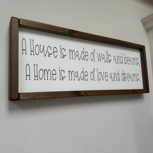 Made in the UK by Giggle Gift Co Rectangular L63.5cm Framed quotable Plaque in old white vinyl; 'A house is made of walls and beams, a home is made of love and dreams.'