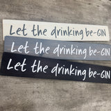 Long L59.5cm Wooden Hanging Plaque;
"Let the drinking be-GIN"

Made in the UK by The Giggle Gift co.