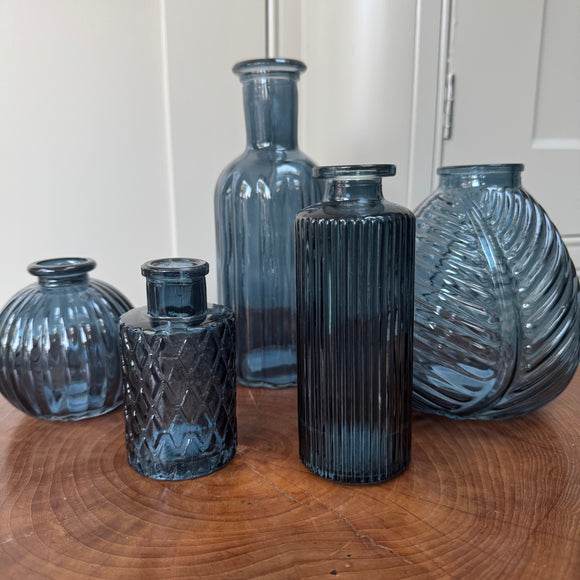 Blue Small Glass Bottle Vases
Various styles
Small Geometric Bottle H9.2cm x 5cm

Leaf bottle Vase H13cm 
Tall Slim Ribbed Vase H22.5 x Dia 10cm
Round Ribbed H8.4 x Dia8.3cm
Slim Ribbed Vase H13.2cm x Dia 5.2cm