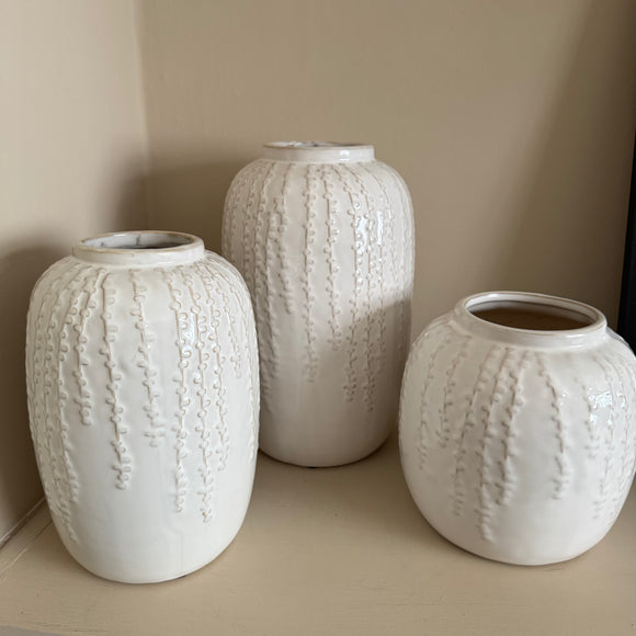 Off White / Cream Glazed Vertical hanging pattern Vases 
Available in 3 sizes; Small H18cm, Medium H24cm & Large H29cm 

These off white / cream glazed distressed effect ceramic vases have a stylish vertical design; similar to the hanging string of pearls plant all at different lengths and depth