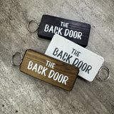 Made in the UK by Giggle Gift Co.
Wooden block keyring with white text quote on both sides;

'The Back Door'&nbsp;