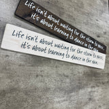 Long Wooden Hanging Sign - 'Life isn't about waiting for the storm..'