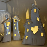 Stone Glazed Ceramic Light up Houses with heart detail
LR44 Battery operated that can be replaced&nbsp;

Available in 2 sizes/shapes: Small split houses H17cm &amp; Large joint H21.5cm