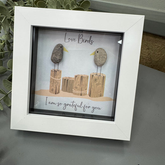 Mini Framed Pebble Art - White block square frame 12.5cm
Image -Two pebble birds facing stood on wooden plinths
Quote - 'Love Birds I am so grateful for you'