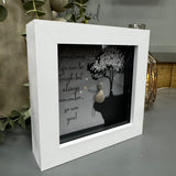 Pebble Art by La De Da Living&nbsp;

Award winning keepsake gifts - Handmade in the Cotswolds&nbsp;

Mini Glitter Framed Pebble Art - White block square frame 12.5cm
Image - Dark image with the sky full of stars, pebble person sitting on grass and a tree full of white glitter blossom
Quote - 'Sometimes life can be tough but always remember so are you!'