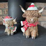 Christmas Highland Cow wearing a hat with holly seasonal scarf with a little sparkle
Available in 2 sizes - Small H10.5cm &amp; Large H17cm