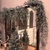 Artificial frosted pine garland dotted with small, realistic pinecones with downward draping cascading needles L183cm