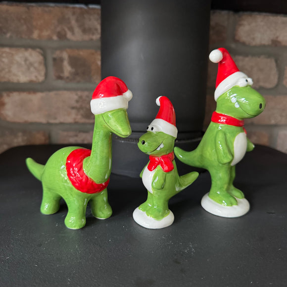 Christmas Ceramic Green Dinosaur Ornaments wearing red santa hats & scarves with a big smile 
Available in Diplodocus & T-Rex in 2 sizes