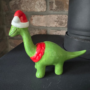 Christmas Ceramic Green Dinosaur Ornaments wearing red santa hats &amp; scarves with a big smile&nbsp;
Available in Diplodocus &amp; T-Rex in 2 sizes